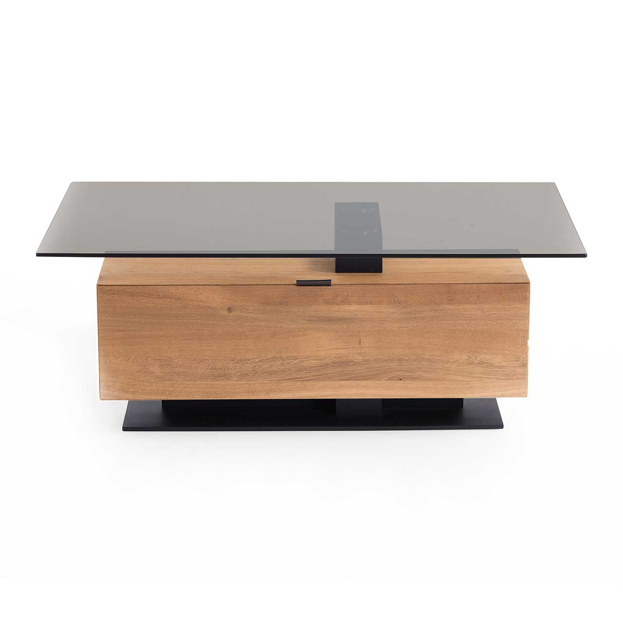 Hartmann NATURWERKE - Couchtisch 7100C-0481 Frontansicht eines modernen Couchtisches mit rechteckiger Glasplatte und Hirnholzblock aus massiver Kerneiche mit Klappe und Stauraumfach auf dunkler Bodenplatte.